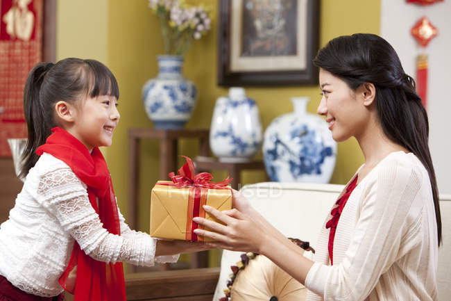 Petite fille présentant cadeau de Nouvel An chinois à la mère — Photo de stock