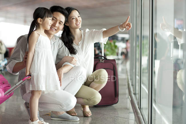 Chinesische Familie zeigt auf Blick am Flughafen — Stockfoto