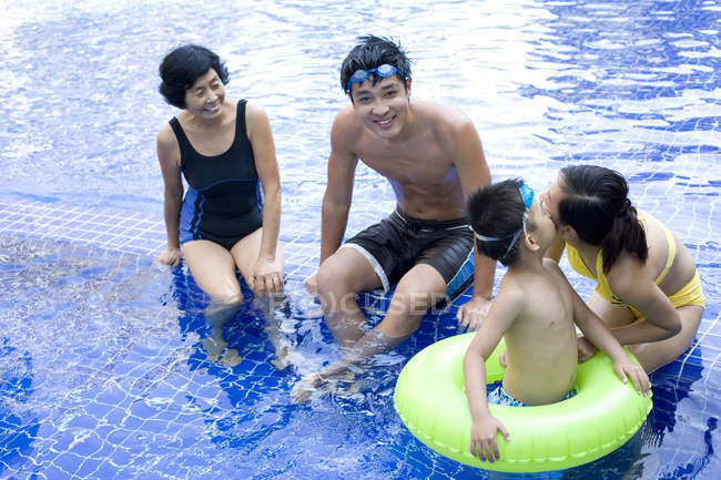 Família chinesa se divertindo e posando na piscina — Fotografia de Stock
