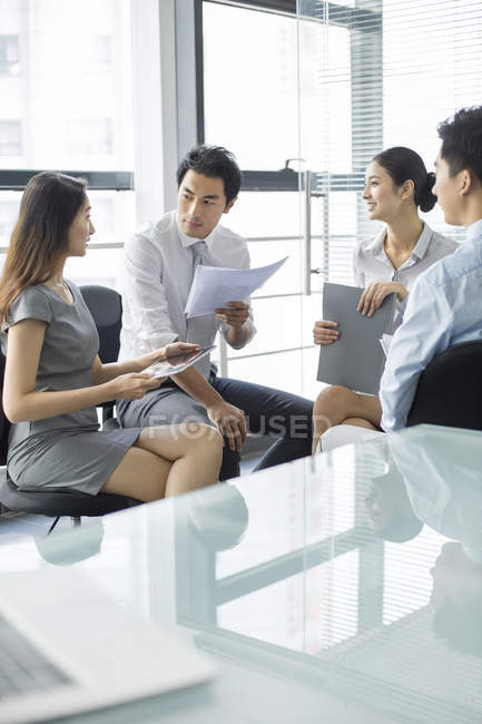 Equipo empresarial chino discutiendo trabajo en reunión - foto de stock