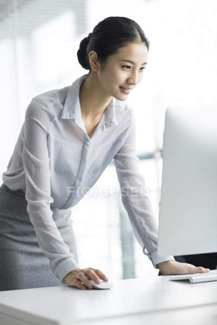 Китайская предпринимательница использует компьютер в офисе — стоковое фото