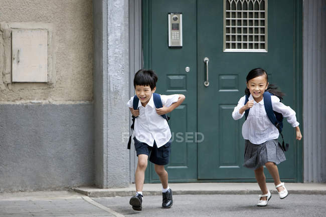 Niños chinos huyendo del edificio escolar - foto de stock