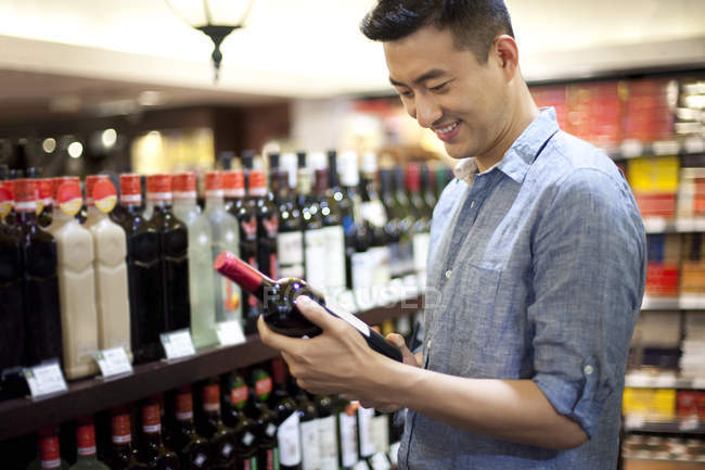Chinois choisissant le vin dans un supermarché — Photo de stock