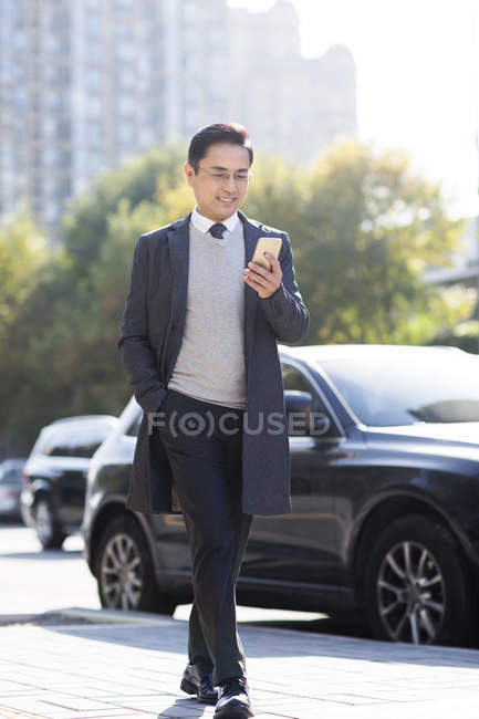 Chinesischer Geschäftsmann nutzt Smartphone auf Stadtstraße — Stockfoto