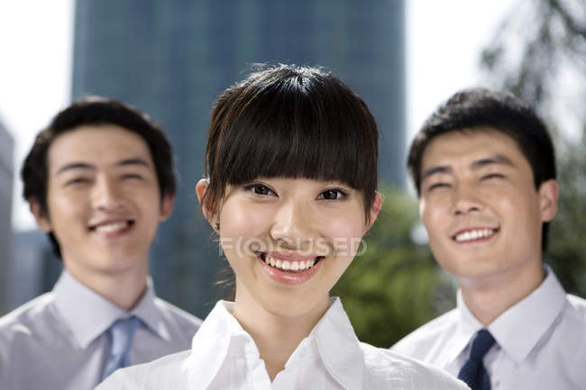 Chinese business professionals in front of skyscraper, portrait — Stock Photo