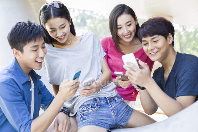 Chinesische Freunde mit Smartphones auf der Straße — Stockfoto
