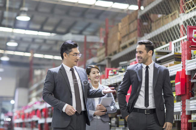 Business people talking while inspecting industrial factory — Stock Photo