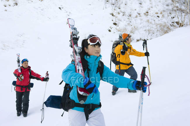 Três esquiadores chineses caminhando em montanhas cobertas de neve — Fotografia de Stock