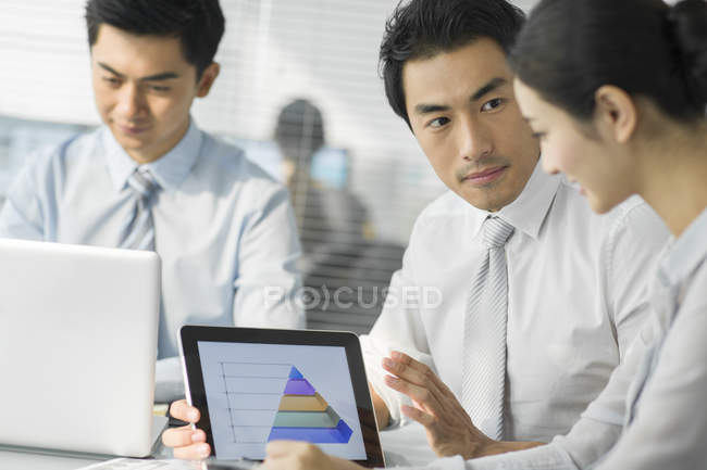 Team aziendale cinese che utilizza tablet digitale in ufficio — Foto stock
