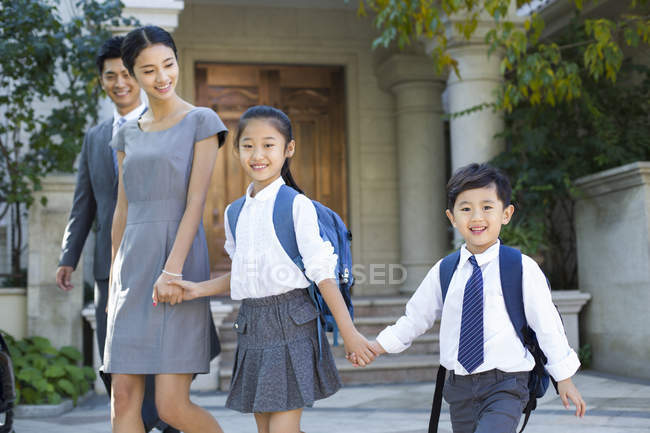 Coppia d'affari cinese con bambini che camminano mano nella mano in strada — Foto stock