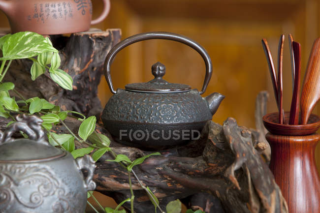 Vintage iron kettle on wooden decoration in tea room — Stock Photo