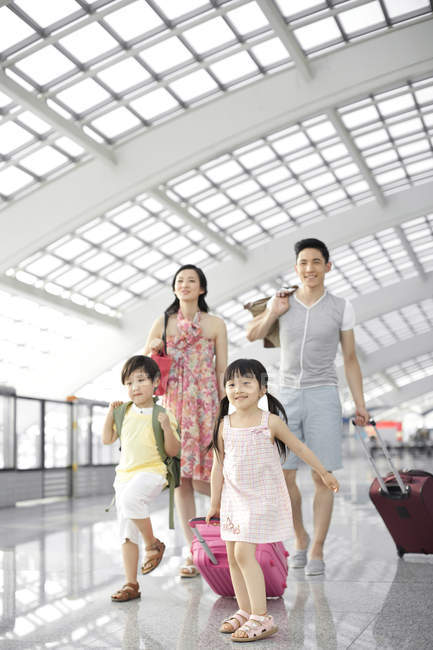 Família chinesa caminhando no lobby do aeroporto — Fotografia de Stock