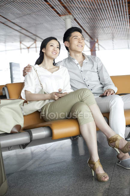 Coppia cinese in attesa nel salone dell'aeroporto — Foto stock
