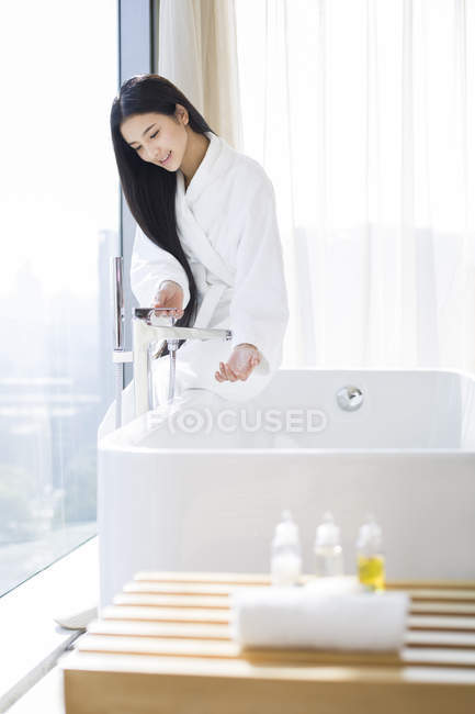 Donna cinese che riempie vasca da bagno con acqua — Foto stock