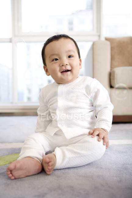 Menino chinês de pijama branco sentado no chão — Fotografia de Stock