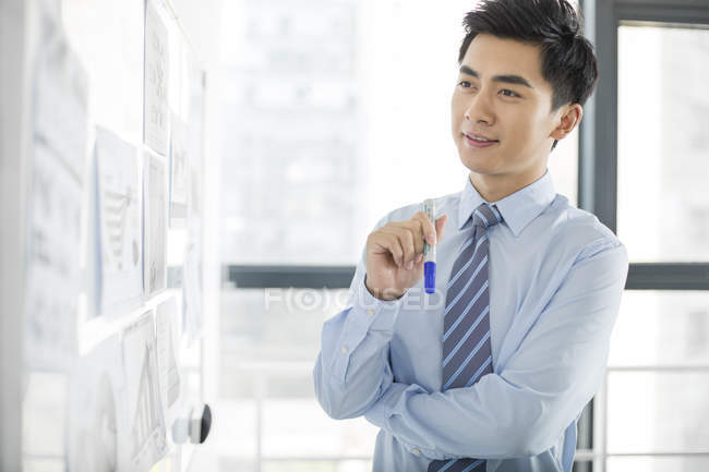 Homem de negócios chinês pensando em quadro branco no escritório — Fotografia de Stock