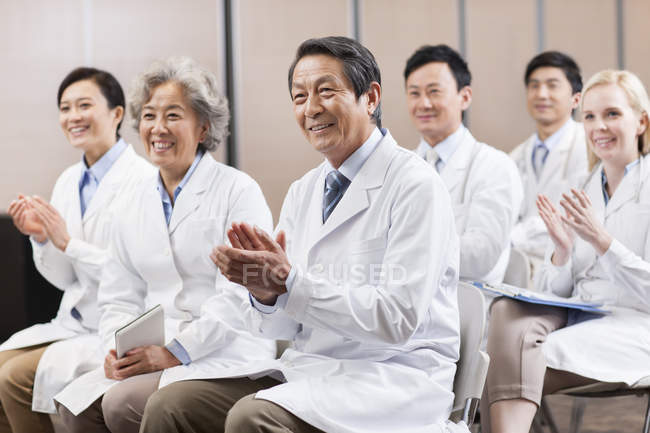 Trabajadores médicos aplaudiendo en reunión - foto de stock