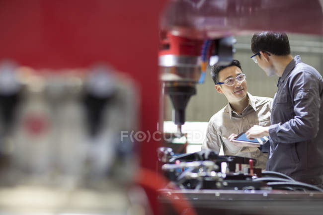 Ingénieurs chinois parlant à la machine dans l'usine — Photo de stock