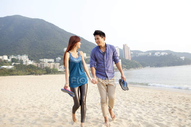 Китайская пара прогуливаясь по пляжу Repulse Bay, Гонконг — стоковое фото