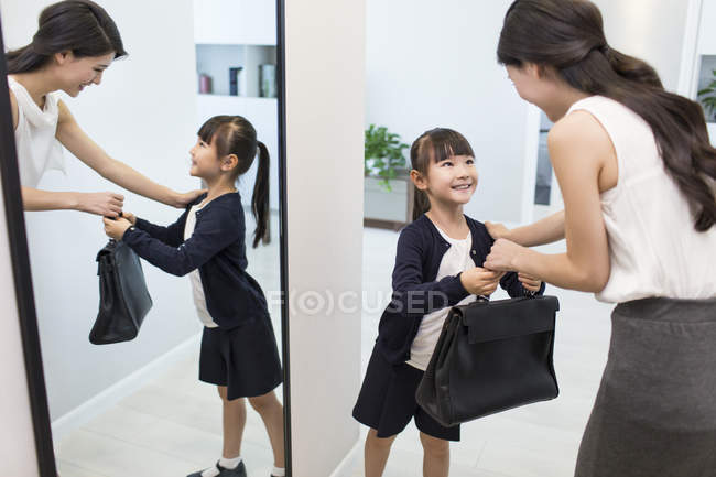 Chino chica dando madre maletín en la mañana - foto de stock