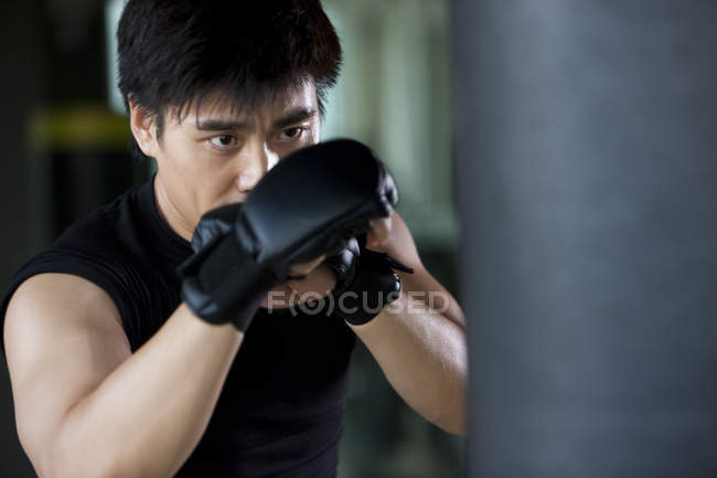 Portrait of Chinese man boxing in gym — Stock Photo
