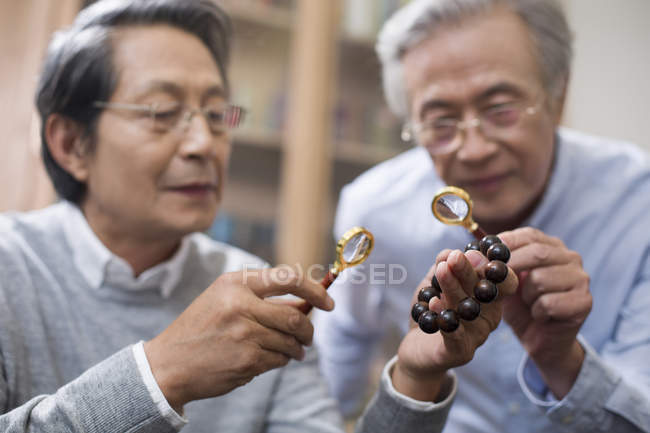 Senior Chinese men admiring antiques — Stock Photo