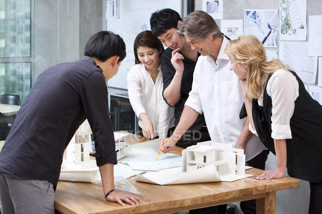 Groupe multi-ethnique d'architectes travaillant avec des plans — Photo de stock