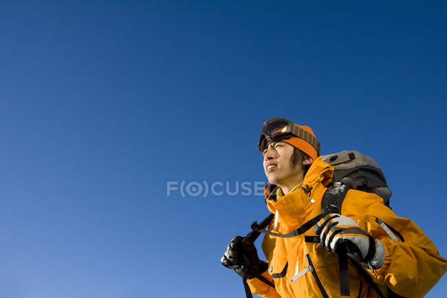 Hombre chino en equipo de esquí sobre fondo azul - foto de stock