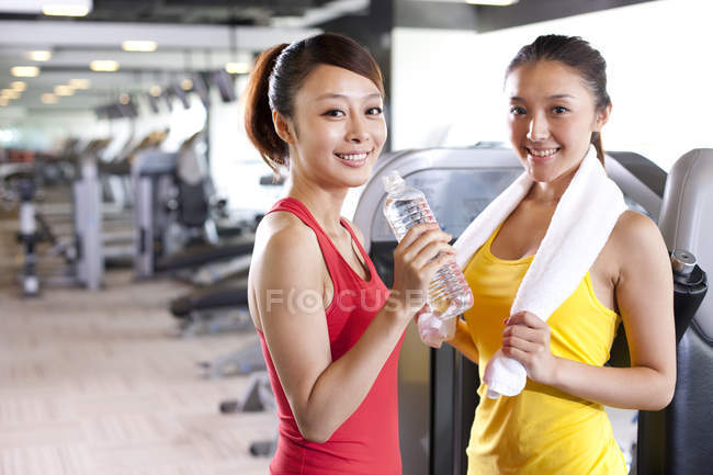 Female Chinese friends resting the gym together — Stock Photo