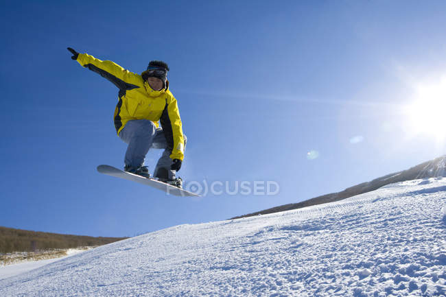 Junger Chinese beim Snowboarden im Skigebiet — Stockfoto