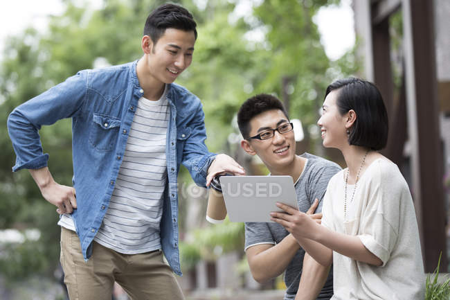 Китайская команда бизнесменов беседует с цифровым планшетом в городе — стоковое фото