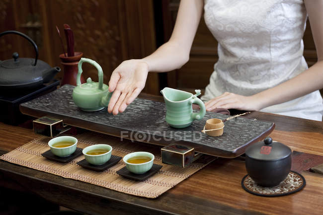 Frau in traditionellem Cheongsam führt chinesische Teezeremonie durch — Stockfoto