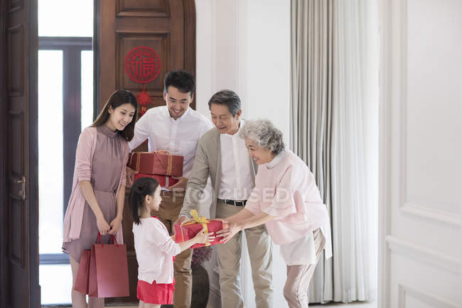 Nieta dando regalos a los abuelos durante el año nuevo chino - foto de stock