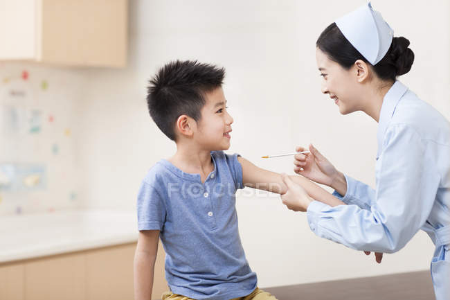 Enfermeira chinesa dando injeção menino — Fotografia de Stock