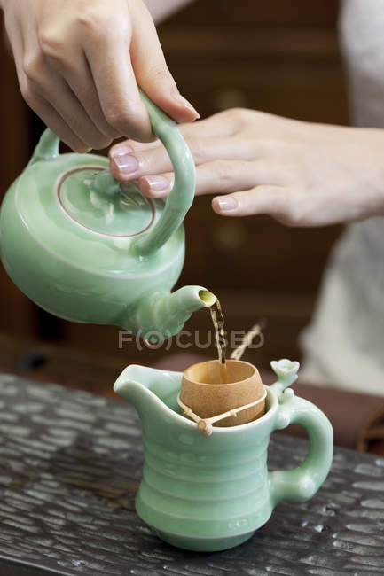 Nahaufnahme weiblicher Hände, die Tee einschenken — Stockfoto