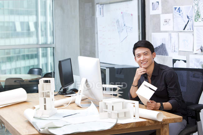 Chinese male architect sitting in office — Stock Photo
