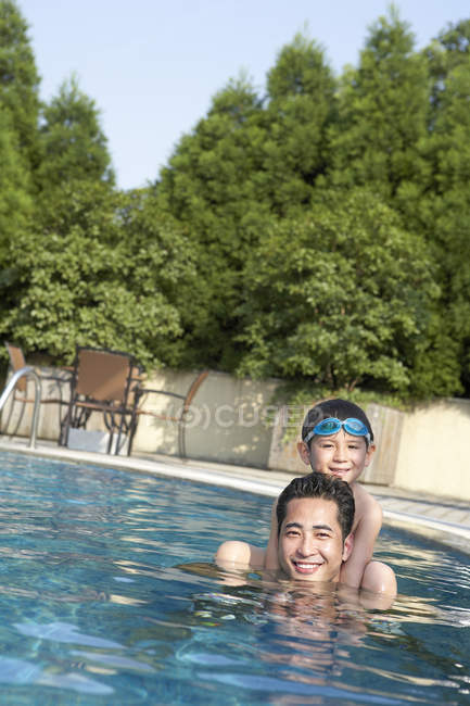 Chinês pai e filho nadando na piscina — Fotografia de Stock