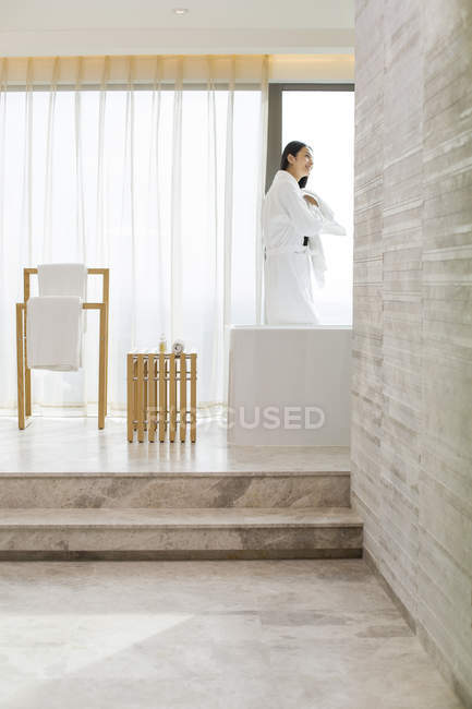 Chinese woman drying hair with towel in bathroom — Stock Photo