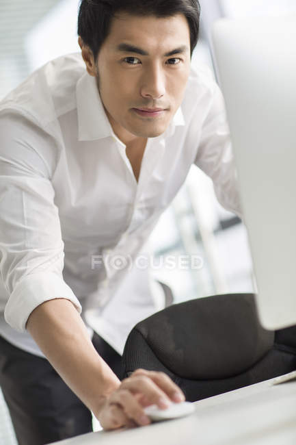 Китайский бизнесмен пользуется компьютером в офисе — стоковое фото