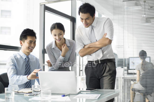 Chinese business people using laptop in office — Stock Photo