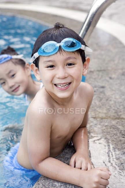 Enfants chinois en lunettes de natation au bord de la piscine — Photo de stock