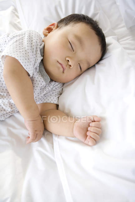 Chinese infant sleeping in bed — Stock Photo