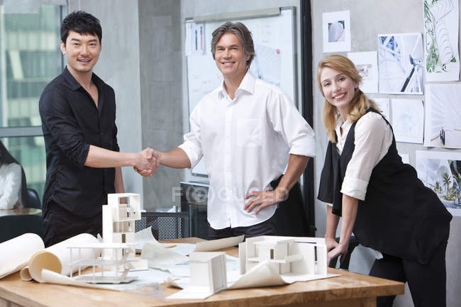 Arquitectos masculinos dando la mano en la oficina - foto de stock