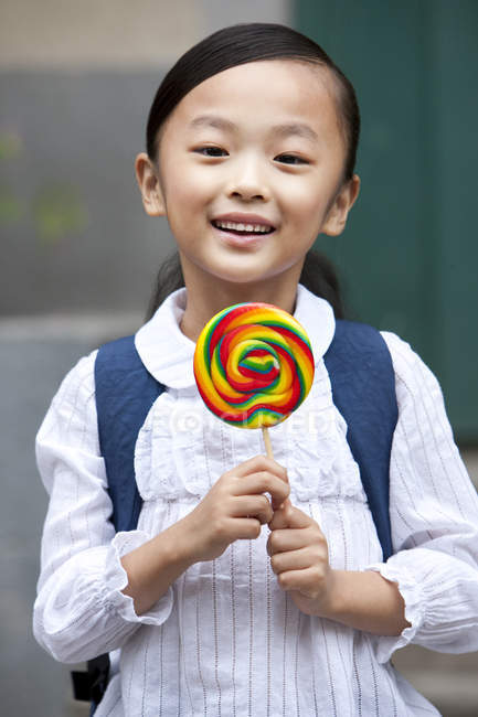 Écolière chinoise tenant sucette sur la rue — Photo de stock
