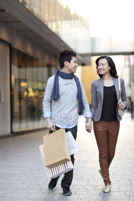 Cinese coppia che si tiene per mano e shopping in città centro — Foto stock