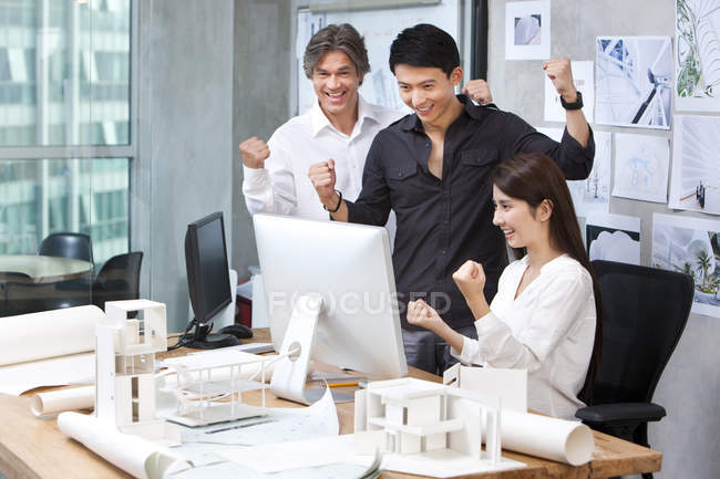Hombre maduro y arquitectos chinos animando en la oficina - foto de stock