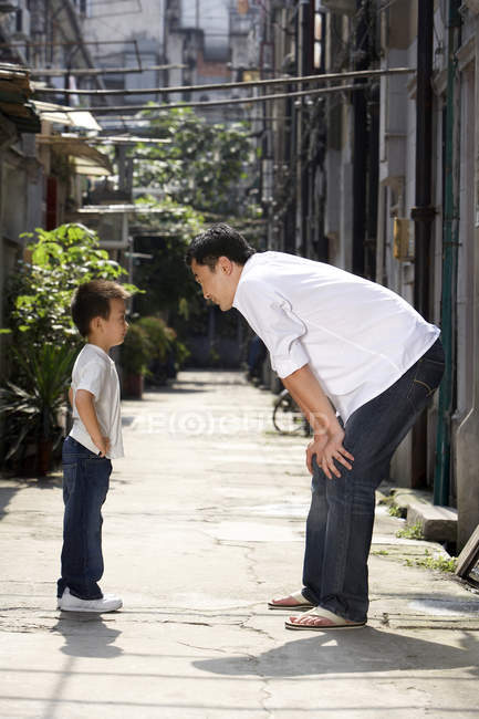 Китайский отец и сын разговаривают в переулке — стоковое фото