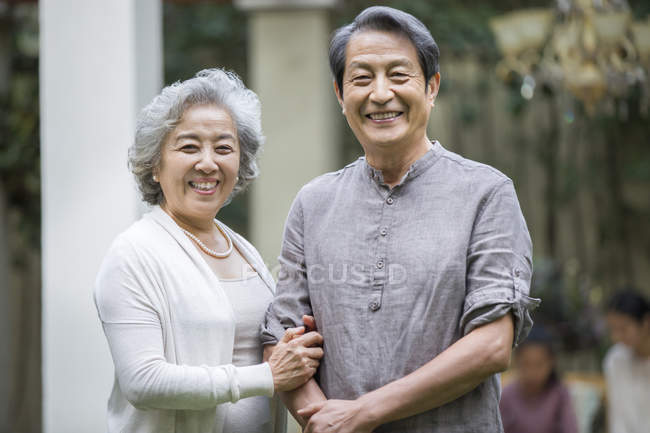Веселая старшая китайская пара, стоящая на улице — стоковое фото