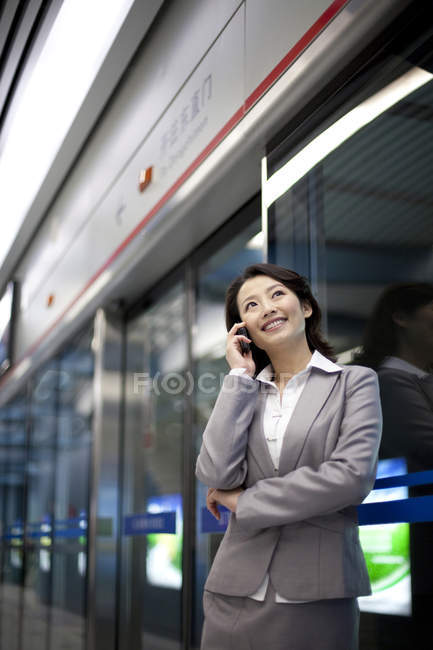 Empresária chinesa falando ao telefone na estação de metrô — Fotografia de Stock