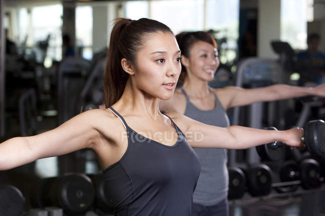 Mujeres chinas levantando pesas en el gimnasio - foto de stock